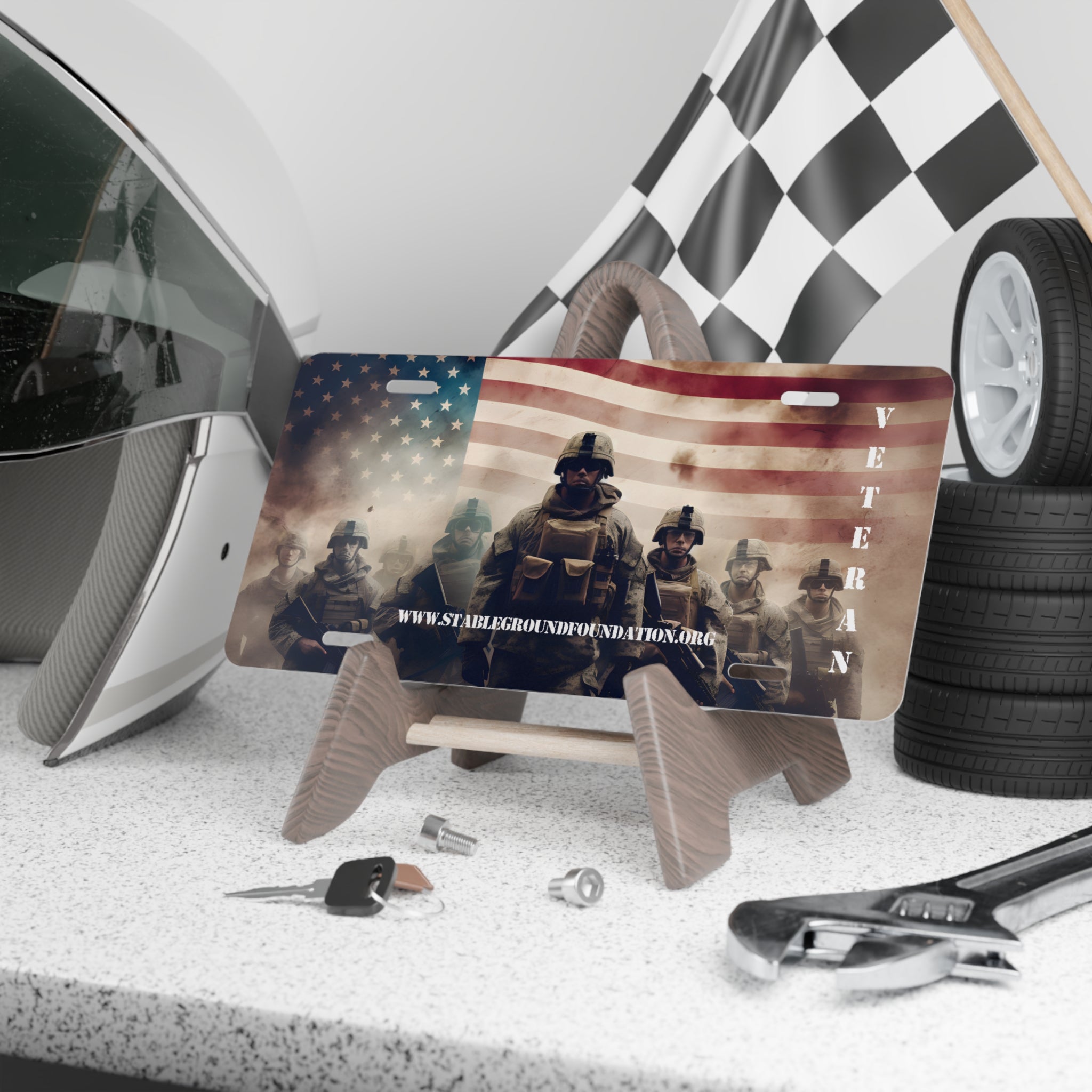 Patriotic veteran license plate with soldiers standing in formation against the American flag background, featuring stablegroundfoundation.org.