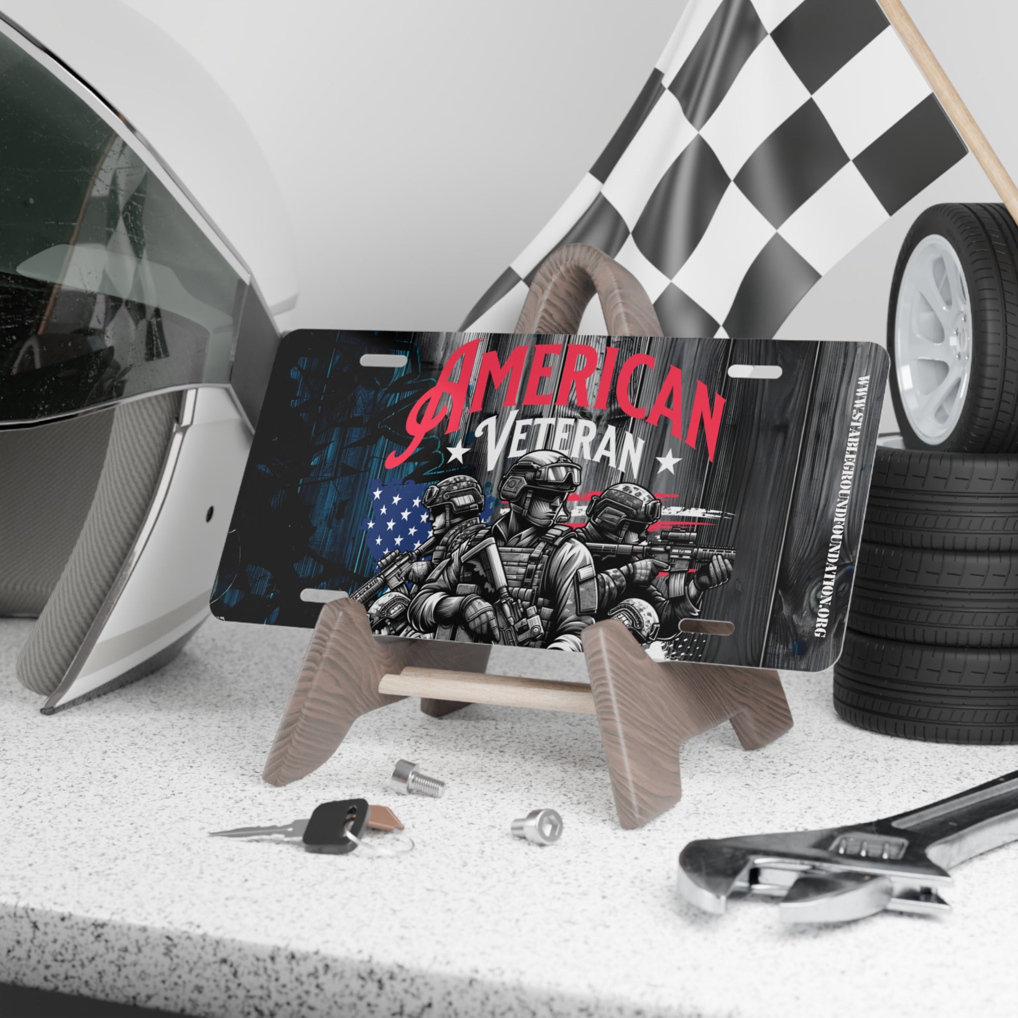 American Veteran metal license plate with soldiers and American flag design, displayed on a car enthusiast’s workbench