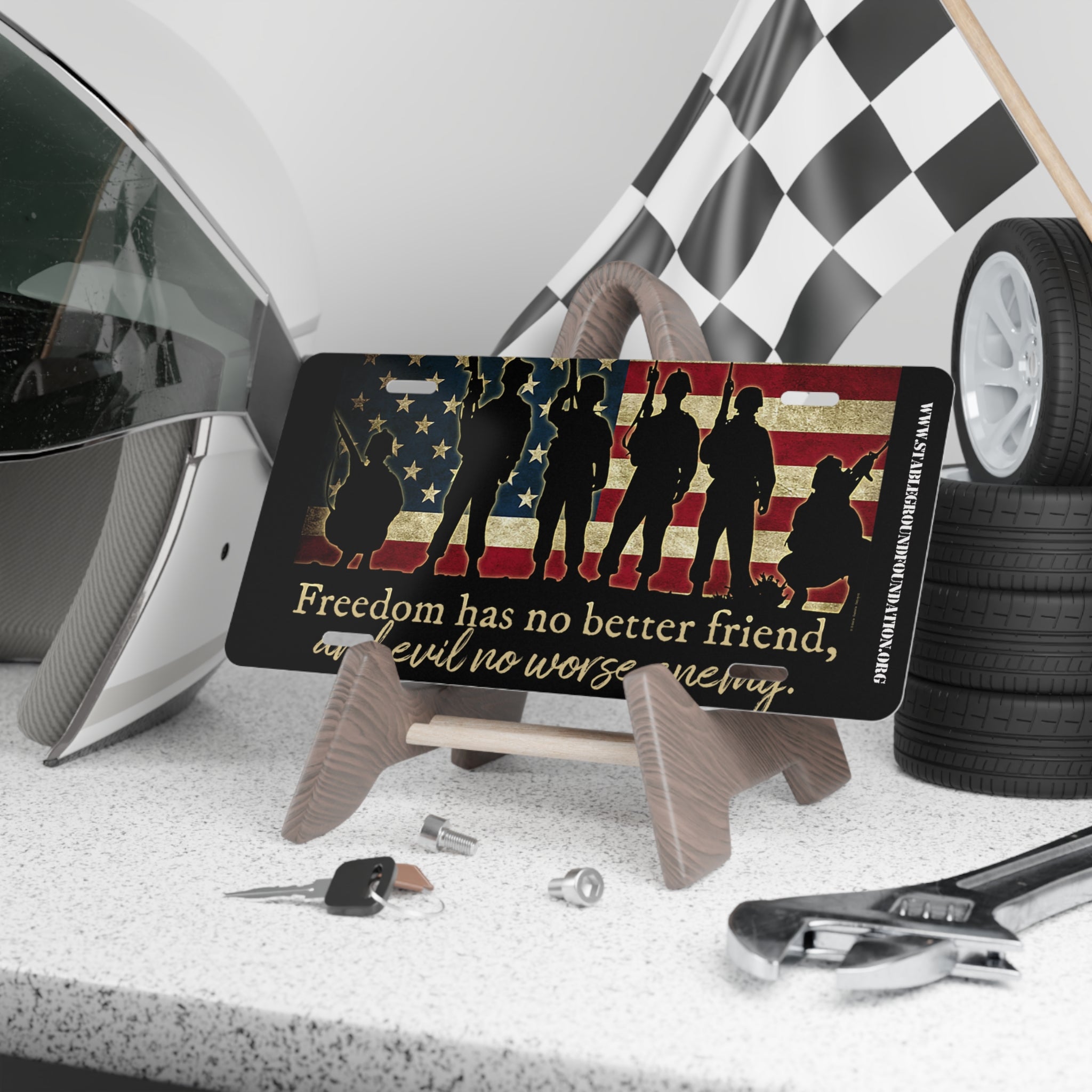Patriotic license plate with American flag background, soldier silhouettes, and quote Freedom has no better friend, and evil no worse enemy.
