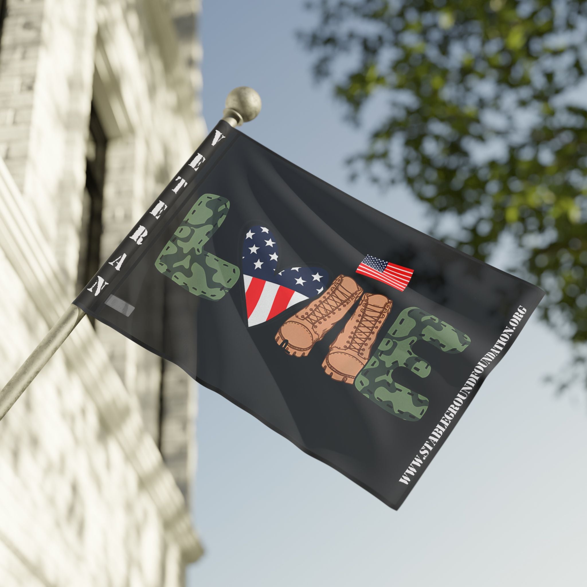 A patriotic flag featuring the word “LOVE” with camouflage letters, combat boots, and an American flag heart, symbolizing pride and appreciation for veterans.