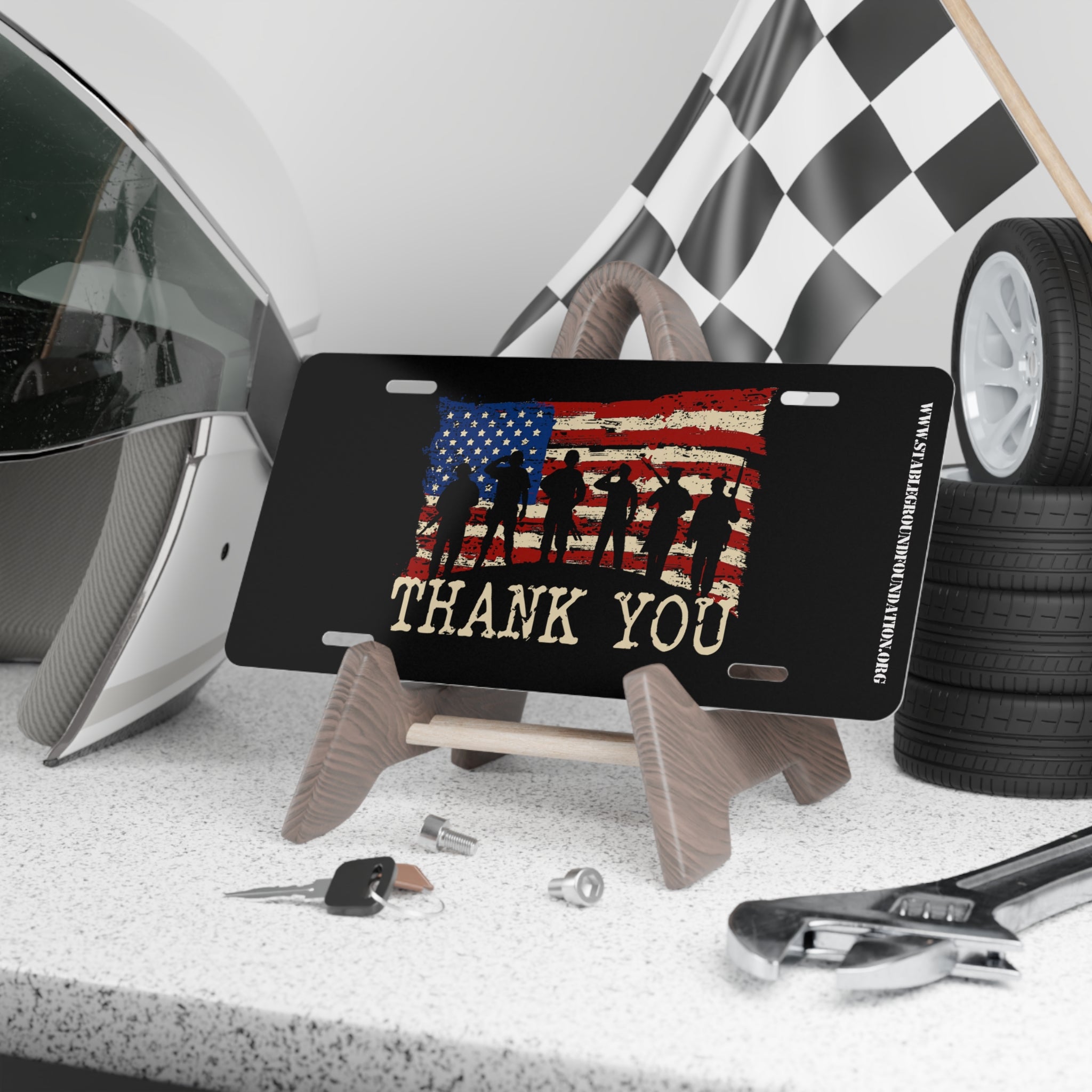 Black license plate with American flag background, soldier silhouettes, and bold text “Thank You.”